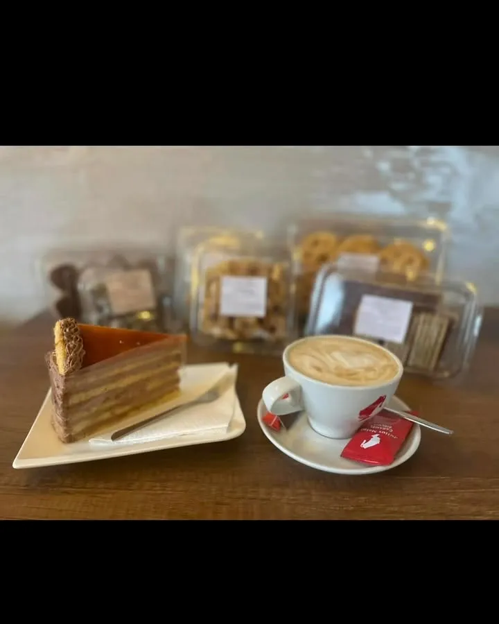 Cappuccino és szeletes sütemény az asztalon