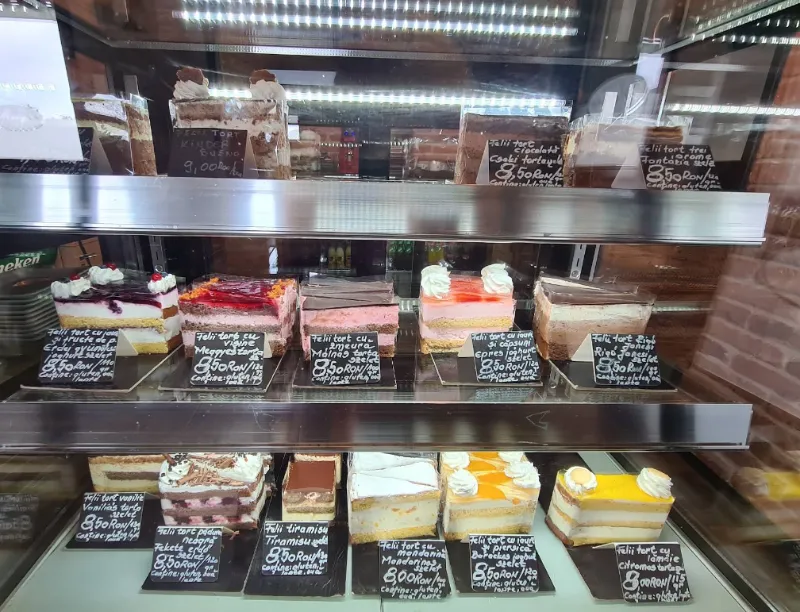 Sütemények a hűtővitrinben, krétatáblás árcímkékkel